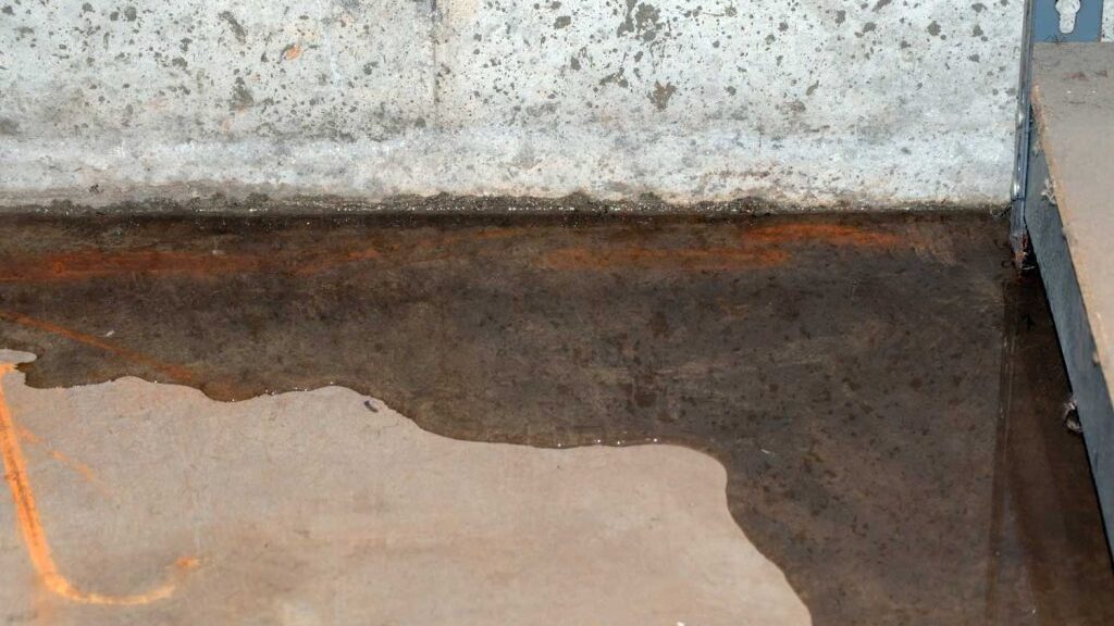 Image of a basement floor with water seeping in from the foundation.