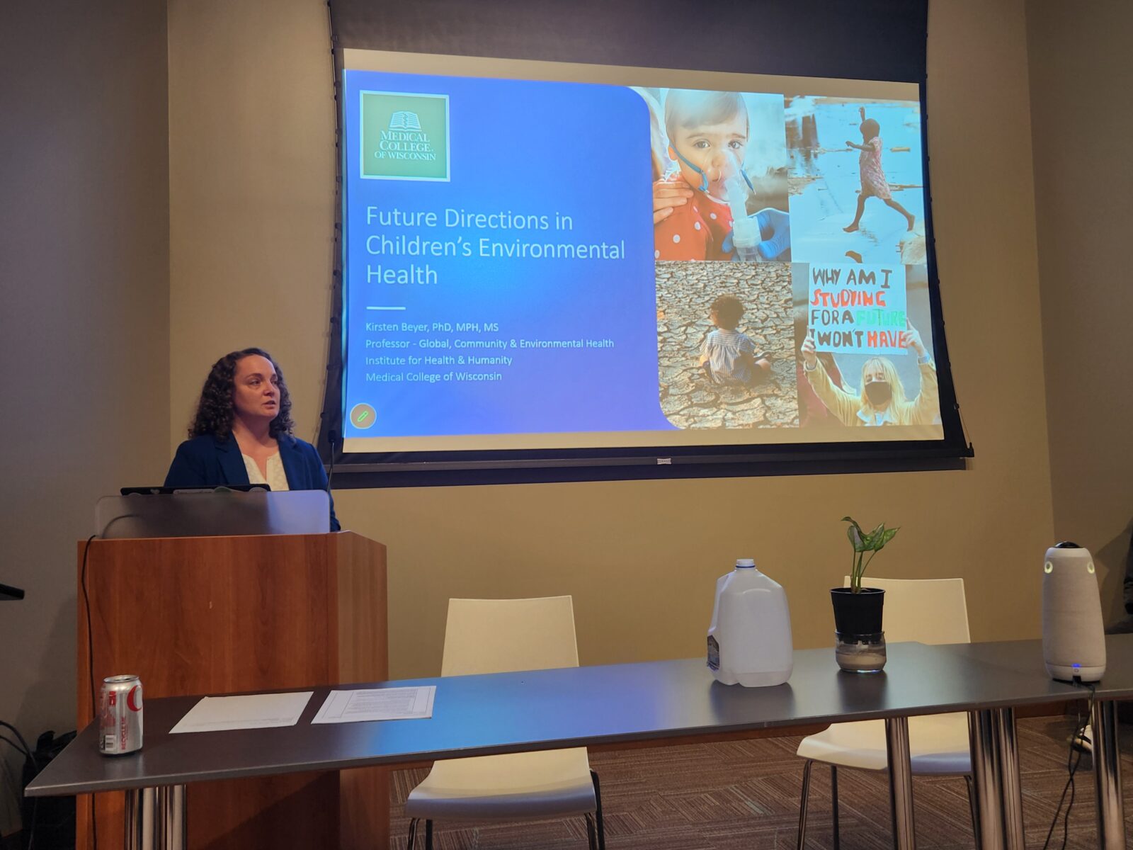 Image of a Dr. Kirsten Beyer presenting slides at the CHEER Symposium.
